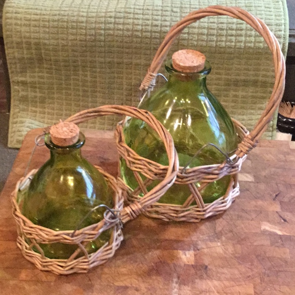 Two green glass jars with wicker handles